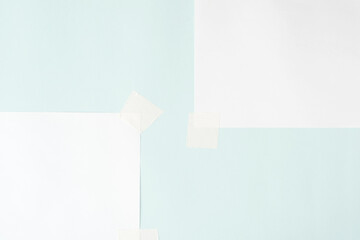 Two blank sheets on scotch tape, layout. White sheets of paper on pastel blue background, copy space