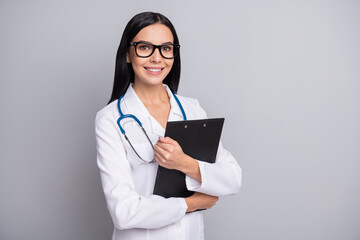 Photo of shiny cheerful woman therapist dressed white uniform eyewear holding clipboard isolated grey color background