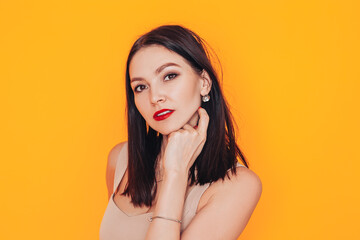 Young woman standing in front of a yellow background. Excellent advertising photo for a banner. Health care. Do-it-yourself makeup at home