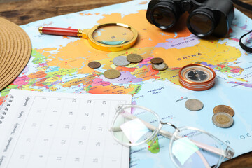 Fototapeta na wymiar Different travel accessories and world map on table, closeup. Planning summer vacation trip