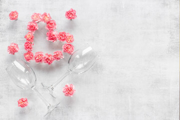 Valentines Day dating dinner with wine glasses and pink flowers. Wedding or birthday background