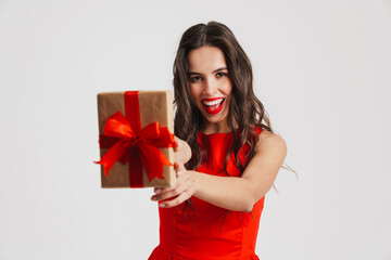 Excited beautiful brunette girl showing gift box at camera
