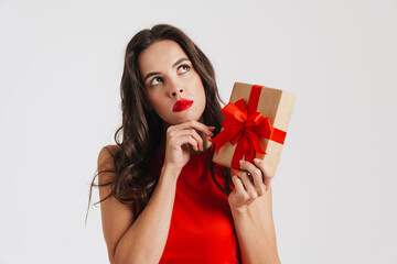 Perplexed beautiful brunette girl posing with gift box