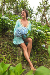 Young and beautiful woman florist collecting Hydrangea flowers
