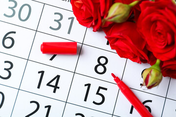 Roses and red marker on calendar near date 8th of March, above view. International Women's Day