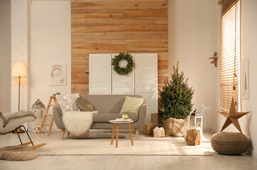 Spacious room interior with small Christmas tree and wreath © New Africa