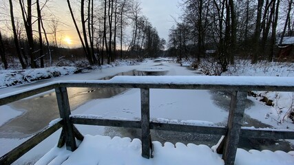 zimowy krajobraz częściowo zamarzniętej rzeki koło Włodawy dużo śniegu niebieskie niebo złota godzina  - obrazy, fototapety, plakaty