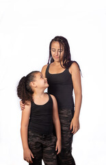 Mother and daughter dressed alike in a very happy rehearsal, white background, selective focus.