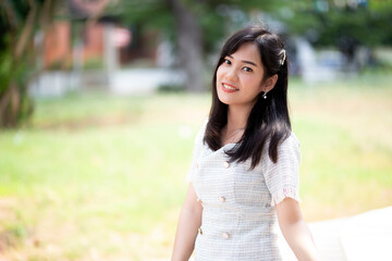 Fototapeta premium Portrait of asian women sitting in the garden with green tree background. A beautiful woman smiling and looking at the camera.