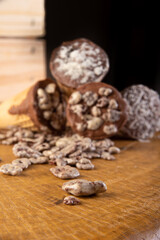 Sweet, ice cream cone filled with chocolate and cream with chocolate flakes, on rustic wood, selective focus.