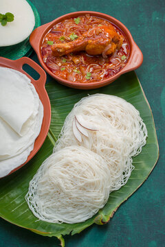 Chicken curry with pathir and ideyappam,a good combination of chicken curry with nice pathiri ,white pathiri and ideyappam arranged on dark green texture background.