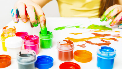 children's creativity. girl painting picture draws with fingers on white background
