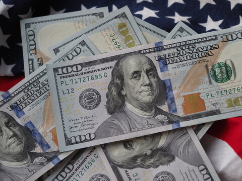 A photo illustration of US 100 dollar bills on American flag