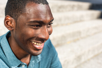 Close up portrait young African American man smiling and looking away