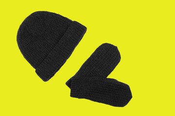 Gray hat and mittens on a yellow background. Trendy colors 2021