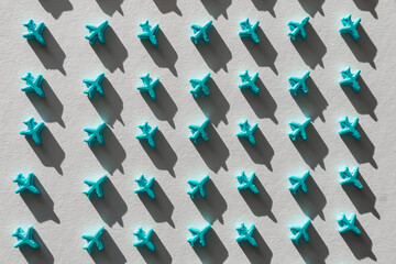 Fototapeta premium Small blue airplane repeated pattern on white background
