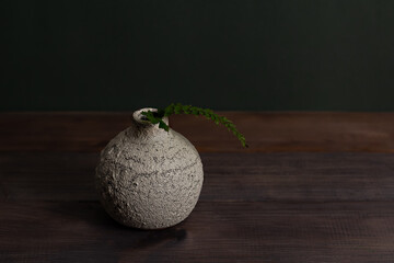 Ceramic vase and a sprig of green fern. Organic. Decor. Free space