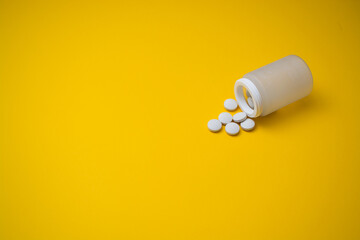  medicine tablets from jars on a yellow background tablets Copy space