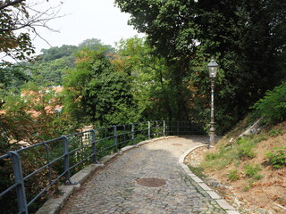 The stone-paved road turns over the hill. Bend in the road. Hill