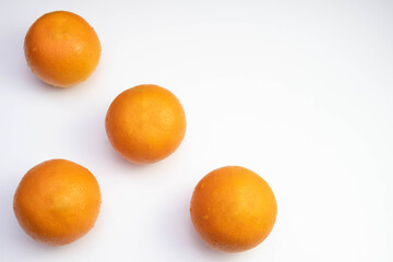 four fresh oranges are spread out on a table