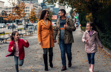 Family of four enjoying together walking through the city.