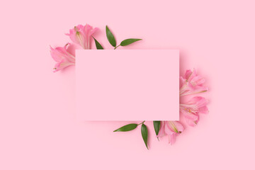 Fototapeta premium Border frame made of alstroemeria flower on a pink pastel background. Paper sheet mockup. Greeting card for 8 March or Mothers Day.