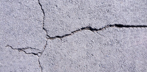 Obraz premium old concrete pavement with cracks and natural destruction from time and weather conditions
