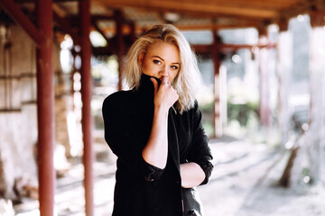 Close-up fashion Portrait of a red-haired girl in black retro country clothes at an old brick factory