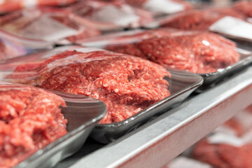 raw minced meat on the shelves of a hypermarket close-up. sale of fresh meat