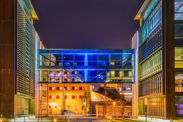 Modern office gangway illuminated at night connects 2 glazed buildings in the city `s financial...