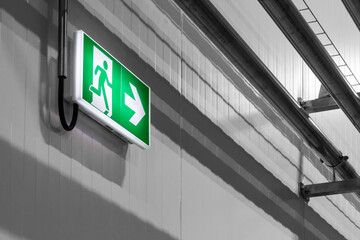 Fototapeta premium green emergency exit sign on a wall