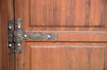 New decorative hinge on a wooden door