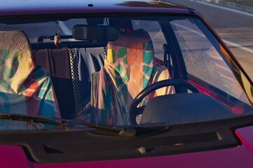 The seats of a red vintage car covered in colorful towels (Marche, Italy, Europe)