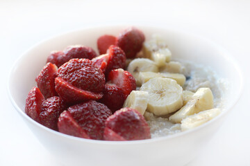Oatmeal with strawberries and banana. Healthy breakfast with fruits. Image with selective focus