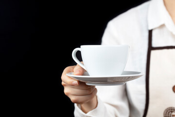 coffee time. A waiter holding and serving a glass of hot coffee isolated on a black background.
