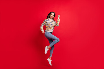 Full length body size photo of jumping up girl gesturing like winner laughing isolated bright red color background