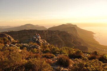 A couple taking a selfie on top of the Table Mountain in Cape Town during sunset hour