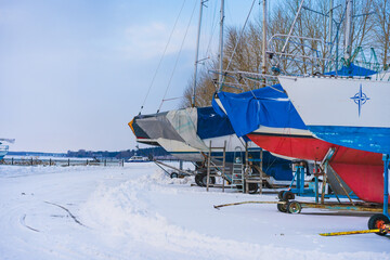 Yachts and boats are stored in winter. Frozen river
