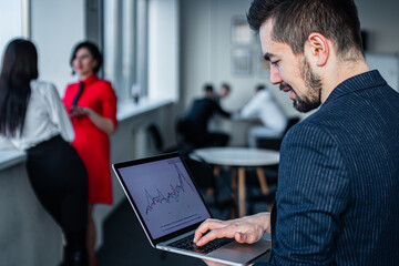 Shot of a young businessman working on a laptop in an office