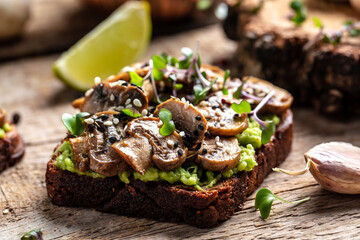 Tasty avocado toast with fried mushrooms and microgreen. Vegetarian food. Vegan menu. Food recipe background. Close up