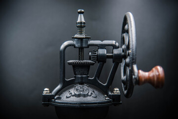 A vintage coffee grinder used by hand to grind coffee.