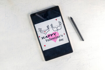 Tablet computer with pink heart and inscription Happy Valentine's day. Tablet PC with Valentine and stylus pen. Valentine's Day Decoration.