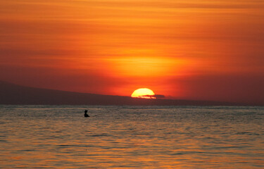 Atardecer en la playa en Bali con barcos fondeados en la arena. Lovina. 
