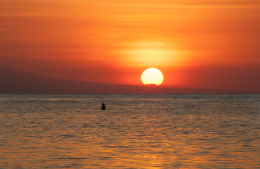 Atardecer en la playa en Bali con barcos fondeados en la arena. Lovina. 