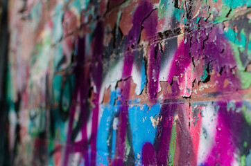 Close up of crumbling graffiti on brick wall in dilapidated industrial estate