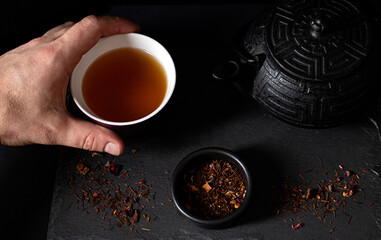 Obraz na płótnie Canvas Red tea cup on a black background