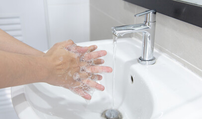 Men are washing their hands in the sinks to clear respiratory bacteria and viruses, sanitation and...