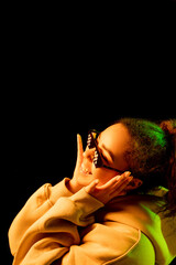 Youth. African-american woman's portrait isolated on dark background in mixed neon light. Wearing trendy pixel eyewear. Concept of human emotions, facial expression, sales, ad, fashion. Copyspace.