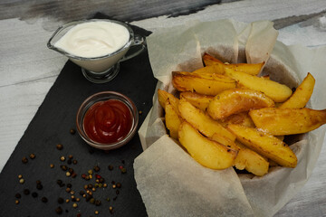 Golden baked new potatoes for dinner. Ketchup sauce and sour cream.