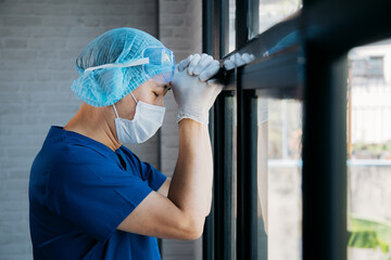 Tired male medical worker working over hours at hospital. Asian overworked professional feeling...